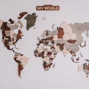 May include: A wooden world map with the text "MY WORLD" on a sign at the top. The map is made of different shades of brown and beige wood and shows the outlines of the continents and countries.