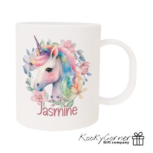 May include: White ceramic mug featuring a colourful unicorn illustration surrounded by flowers. The unicorn has a pink, blue and yellow mane and tail. The name "Jasmine" is printed below the unicorn.