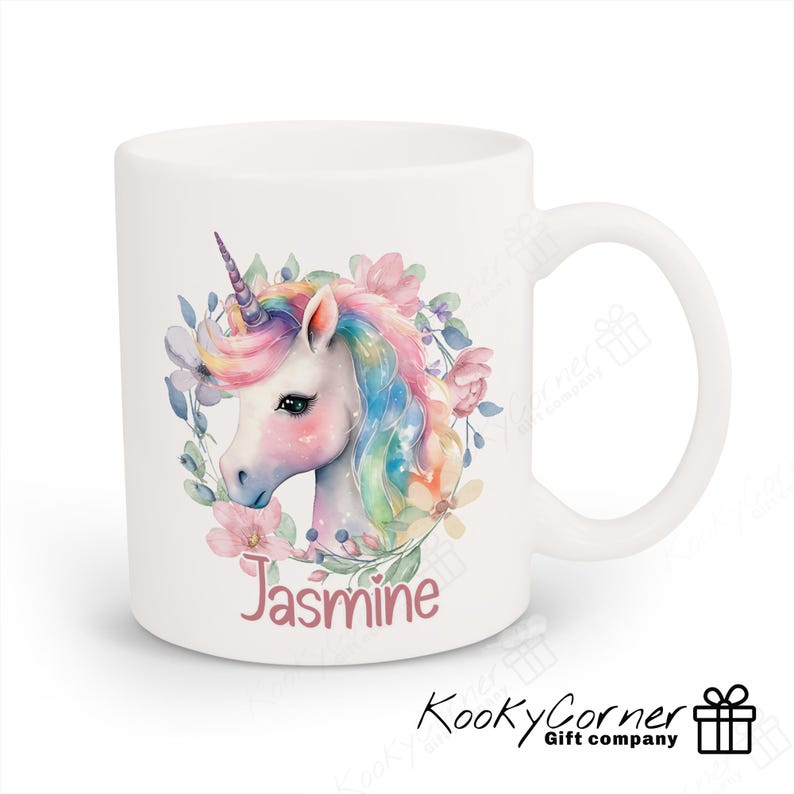 May include: White ceramic mug featuring a watercolour illustration of a unicorn with a rainbow mane and flowers. The name "Jasmine" is printed in pink below the unicorn.