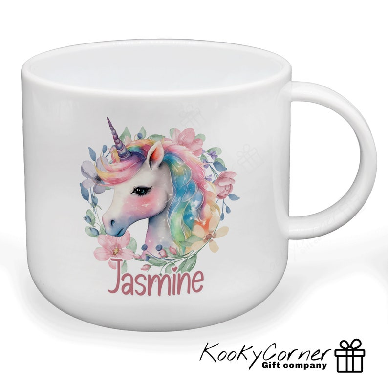 May include: White ceramic mug featuring a colourful unicorn illustration and floral wreath. The name "Jasmine" is written in pink below the unicorn.