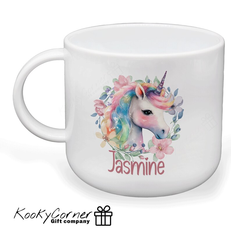 May include: White ceramic mug featuring a colourful unicorn illustration and floral wreath. The name "Jasmine" is written in pink below the unicorn.