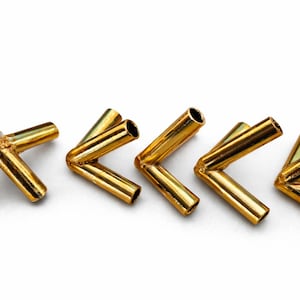 Può includere: Cinque connettori metallici dorati a forma di L disposti su sfondo bianco. Ogni connettore ha due tubi cilindrici uniti ad angolo retto. I connettori sono distanziati uniformemente e sembrano essere in ottone o materiale simile.