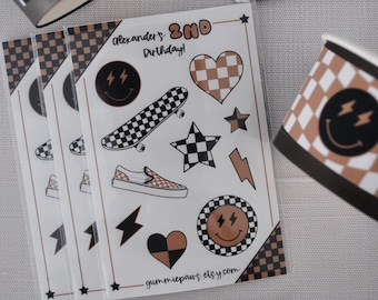 May include: A set of party favor stickers with a checkered and lightning bolt theme. The stickers feature a skateboard, a heart, a star, a lightning bolt, and a smiley face. The stickers are printed on white paper and have a black and brown checkered pattern. The text "Alexander's 2nd Birthday!" is printed on the sticker sheet. The text "gummiepaws.etsy.com" is printed at the bottom of the sticker sheet.