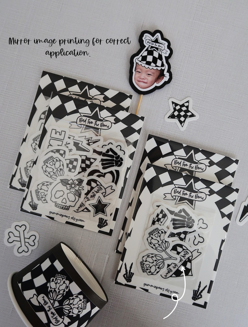 Puede incluir: Un conjunto de pegatinas en blanco y negro con una calavera, huesos, corazones, estrellas y el texto "Bad to the Bone". Las pegatinas est&aacute;n empaquetadas en bolsas de pl&aacute;stico transparentes con un fondo a cuadros.
