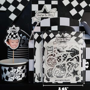 Puede incluir: Un conjunto de art&iacute;culos para fiestas en blanco y negro con un tema de calavera y huesos cruzados. El conjunto incluye un adorno para cupcake, una hoja de pegatinas y una taza. La hoja de pegatinas presenta una variedad de dise&ntilde;os de calaveras y huesos cruzados, incluyendo una calavera con una flor, una calavera con una corona y una calavera con un pa&ntilde;uelo. El texto en la hoja de pegatinas dice "Bad to the Bone" y "gummiepaws elsy.com". La hoja de pegatinas mide 11,4 cm de alto y 8,8 cm de ancho.