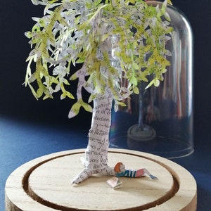 Scultura di carta ritagliata, ragazzino ai piedi di un albero con un libro