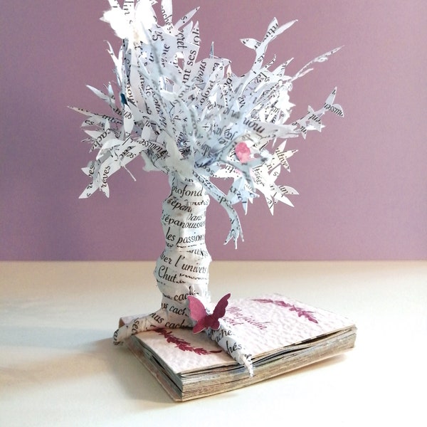 Sculpture en papier découpé posée sur un mini livre "jardin secret"