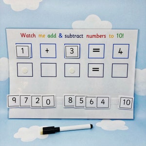 May include: A white dry-erase board with the text "Watch me add & subtract numbers to 10!"  The board has a grid of squares with numbers 1, 3, and 4 written in black marker. There are also blank squares for writing numbers. Below the grid, there is a row of squares with the numbers 9, 7, 2, 0, 8, 5, 6, 4, and 10 written in black marker. A white dry-erase marker is lying on a blue surface.