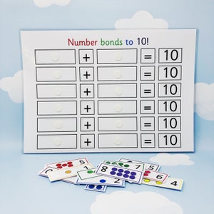 May include: A white board with the title "Number bonds to 10!" and six rows of blank spaces for number bonds.  Below the board are colorful cards with numbers 1 through 8, each with a corresponding number of dots.