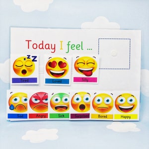 May include: A white board with the text "Today I feel..." and a variety of colourful emoji faces representing different emotions. The emotions include tired, loved, silly, sad, angry, sick, surprised, bored, and happy.