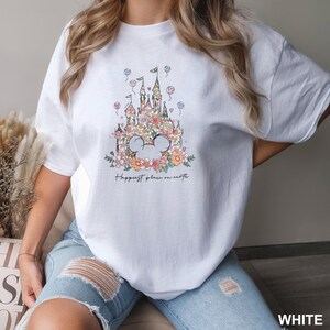 a woman wearing a white shirt with a castle on it