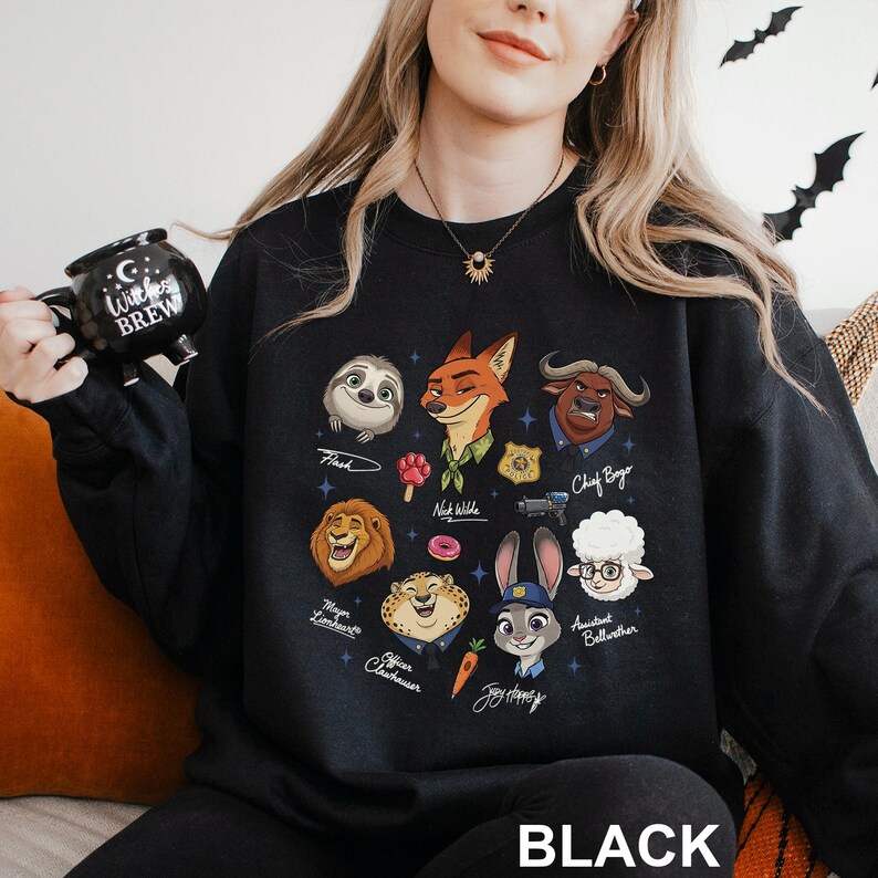 May include: Black sweatshirt featuring cartoon illustrations of characters from a popular animated movie. The design includes a sloth, fox, lion, and other animal characters. The word "BLACK" is printed at the bottom of the sweatshirt.