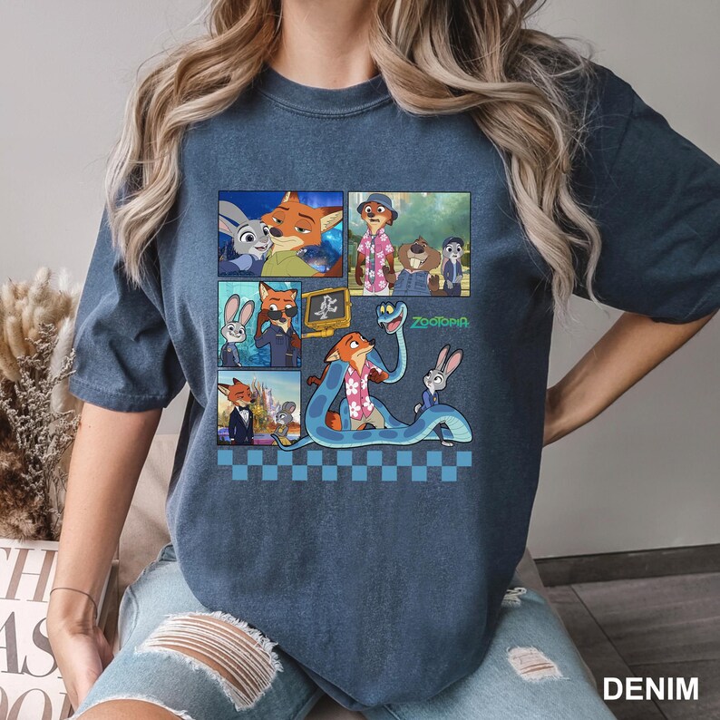 以下が含まれることがあります： アニメ映画「ズートピア」のキャラクターが描かれた、デニムブルーのTシャツ。キツネ、ウサギ、その他のキャラクターの画像が複数のパネルに配置されています。「ズートピア」の文字も確認できます。