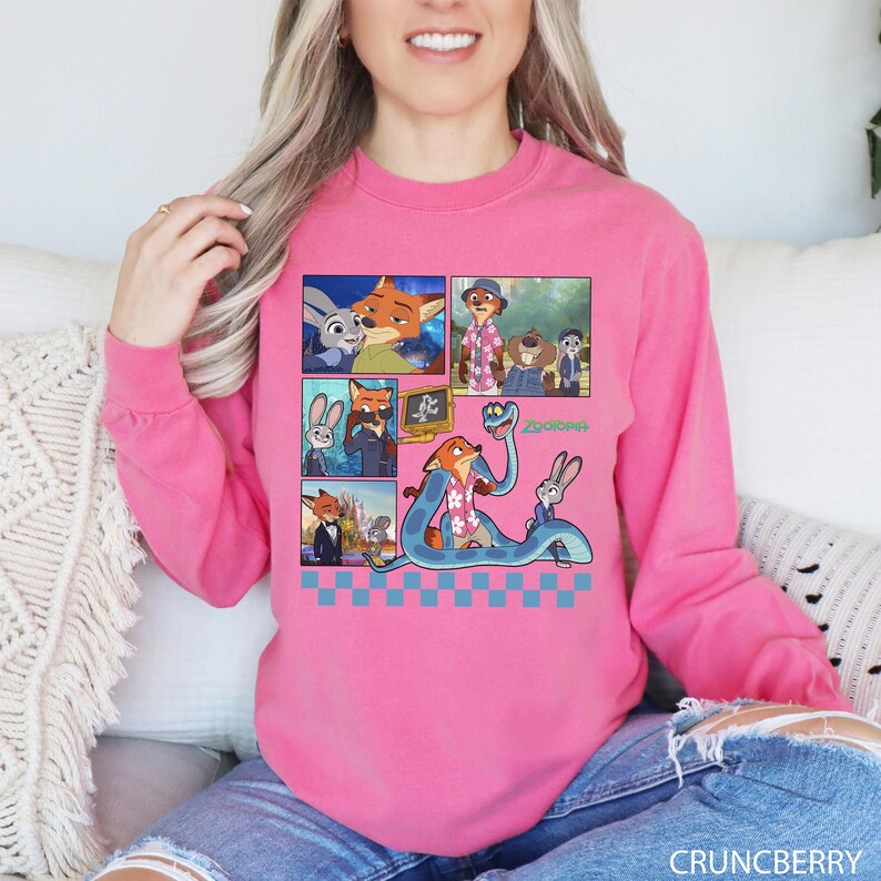 以下が含まれることがあります： アニメ映画「ズートピア」のキャラクターが描かれた、鮮やかなピンク色の長袖スウェットシャツ。グラフィックには、キツネ、ウサギ、その他のキャラクターの画像が含まれています。「ズートピア」という文字も表示されています。