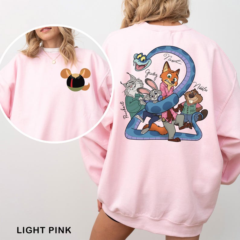 Op de afbeelding: Lichtroze sweatshirt met een cartoonontwerp op de achterkant, met een blauwe slang en dierenfiguren. De voorkant heeft een klein cartoonontwerp. De tekst "LIGHT PINK" staat onderaan.