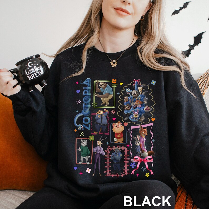 Puede incluir: Sudadera negra de Zootopia con ilustraciones coloridas de personajes en cuadros enmarcados. La palabra "Zootopia" est&aacute; escrita verticalmente en azul. La palabra "BLACK" est&aacute; impresa en blanco en la parte inferior de la sudadera.