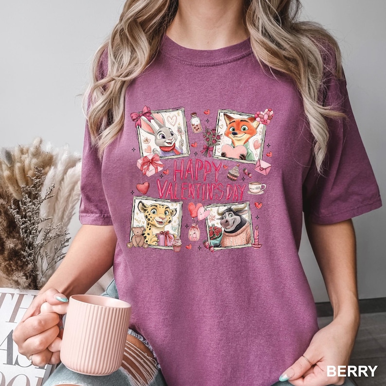 May include: Berry-colored t-shirt featuring a graphic with four framed cartoon characters and the text "HAPPY VALENTINE'S DAY." The characters include a rabbit, fox, cheetah, and a bull, each with Valentine's Day-themed elements like hearts and gifts.