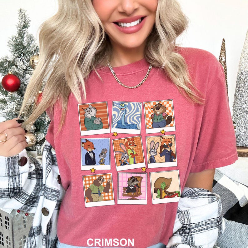 May include: Crimson-colored t-shirt featuring a grid of cartoon character portraits. The portraits are in a polaroid style, with a variety of animal characters in different outfits. The word "CRIMSON" is printed at the bottom of the shirt.