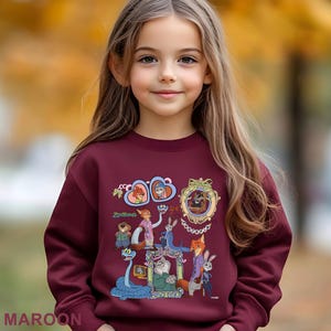 May include: A maroon sweatshirt with a colourful graphic of characters from the animated film "Zootopia." The design includes framed portraits and various animal characters. The word "Zootopia" is printed in a stylized font. The word "MAROON" is printed at the bottom.