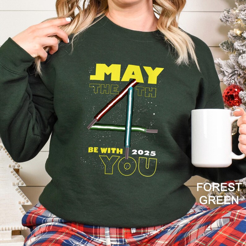 May include: A set of three ceramic mugs with a speckled, cream-coloured glaze. Each mug features a different hand-painted design: a blue and green leaf, a yellow flower, and a red berry. The mugs have a simple, rounded shape.