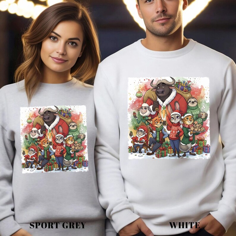 Op de afbeelding: Sportgrijze en witte sweatshirts met een kleurrijke illustratie van Zootopia-personages in feestelijke kleding. Het ontwerp toont een buffel met een kerstjas, een luiaard en andere personages, omringd door cadeaus en een kerstboom.