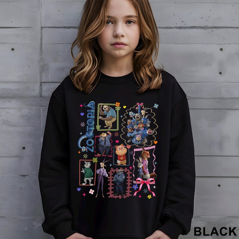 Puede incluir: Sudadera negra con personajes de dibujos animados coloridos de Zootopia. El dise&ntilde;o incluye varias im&aacute;genes enmarcadas de los personajes, la palabra "Zootopia" y la palabra "BLACK" en la parte inferior derecha.