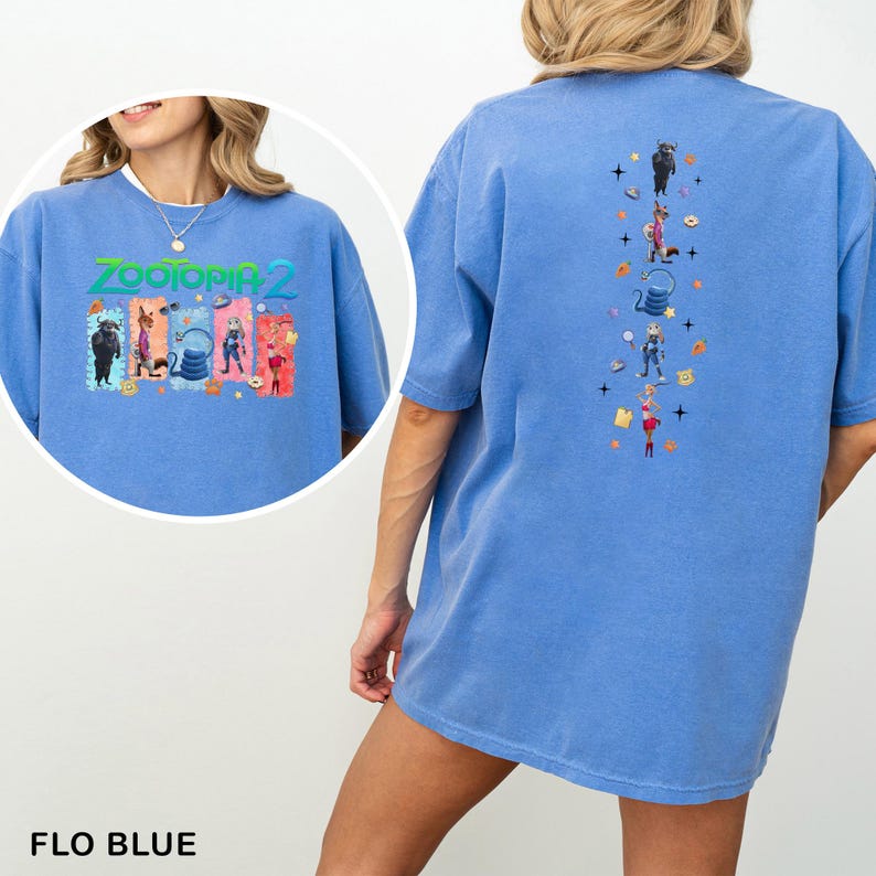 May include: Flo blue t-shirt featuring a colorful graphic from Zootopia 2 on the front and back. The front graphic includes the text "Zootopia 2" and various characters. The back graphic has a vertical arrangement of characters and icons.