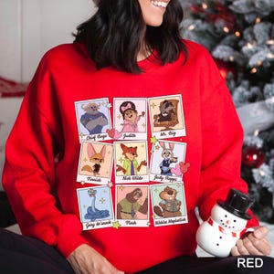 Puede incluir: Una sudadera roja con una cuadr&iacute;cula de retratos de personajes de dibujos animados. Cada retrato tiene un nombre de personaje debajo. Los personajes incluyen Chief Bogo, Judith, Mr. Big, Finnick, Nick Wilde, Judy Hopps, Gary de'snack, Flash y Nibbles Maplestick.