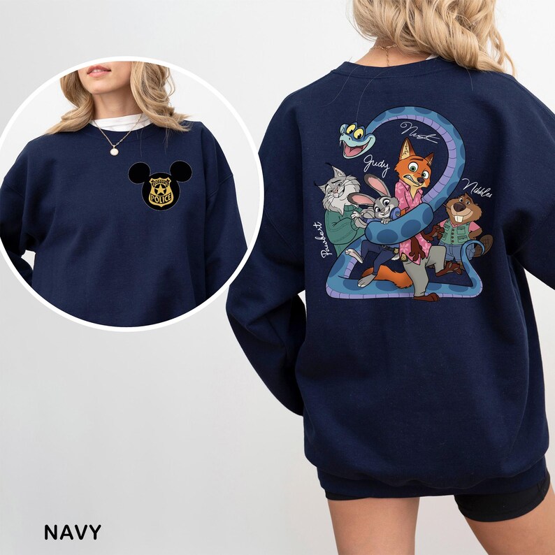 Op de afbeelding: Marineblauw sweatshirt met een Mickey Mouse politiebadge op de voorkant. De achterkant heeft een cartoonafbeelding van filmkarakters, waaronder een slang, een vos, een konijn en een bever. Het woord "Navy" staat onderaan.