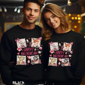 May include: Black sweatshirts with a Valentine's Day design. The design features cartoon characters in frames, pink hearts, and the text "Happy Valentine's Day". The sweatshirts are worn by a couple.