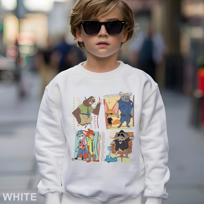 May include: A white sweatshirt featuring a colorful graphic of characters from the animated movie Zootopia. The design includes images of a sloth, fox, buffalo, and raccoon. The word "WHITE" is printed at the bottom.