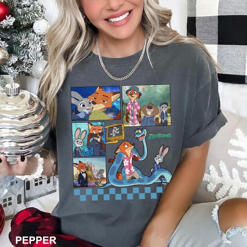 以下が含まれることがあります： アニメ映画「ズートピア」のキャラクターが描かれた、ダークグレーのTシャツ。キツネ、ウサギ、その他のキャラクターの画像が含まれています。「ズートピア」の文字は緑色で印刷されています。Tシャツは半袖です。