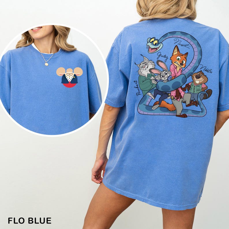 May include: A light blue t-shirt with a cartoon mouse in a suit on the front. The back of the shirt has a cartoon illustration of animals and a snake. The text "Judy", "Nick", and "Nibbles" are written on the shirt.