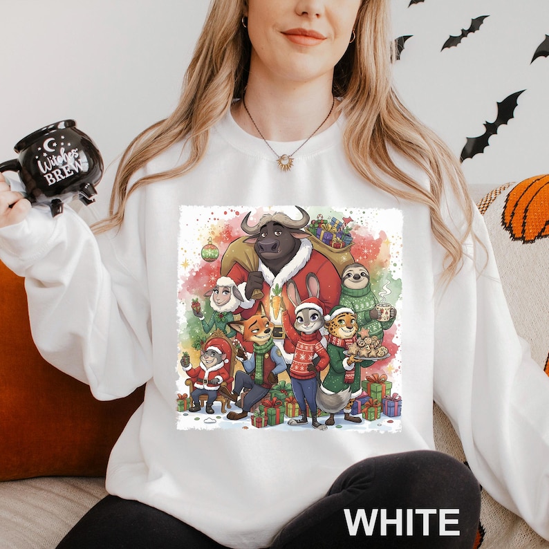 Op de afbeelding: Witte sweatshirt met een kleurrijke aquarel illustratie van dierenfiguren in feestelijke kleding, omringd door cadeaus. Het woord "WHITE" staat onderaan de sweatshirt.