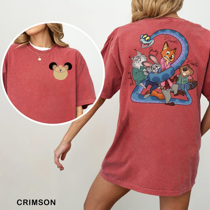May include: Crimson-coloured t-shirt with a cartoon mouse on the front and a group of cartoon characters with a snake on the back. The back design includes the names Judy, Nick, and others. The shirt is a comfortable, casual style.