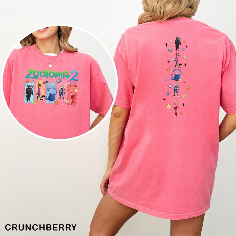 May include: A pink t-shirt featuring the text "ZOOTOPIA 2" with cartoon characters. The back of the shirt has a vertical design of cartoon characters. The shirt is a solid pink color and has short sleeves.