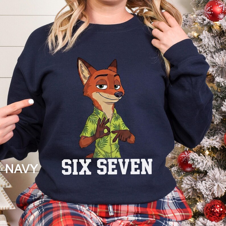May include: Navy blue sweatshirt featuring a cartoon fox character in a green Hawaiian shirt. The fox is making an "okay" hand gesture. The words "SIX SEVEN" are printed in white block letters below the fox.