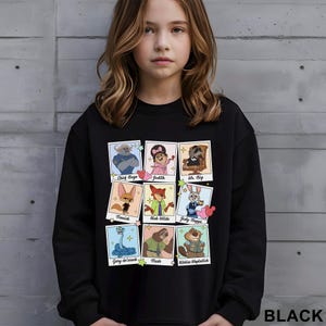 Puede incluir: Sudadera negra con una cuadr&iacute;cula de retratos de personajes de dibujos animados de una pel&iacute;cula. Los personajes incluyen a Chief Bogo, Judith, Mr. Big, Finnick, Nick Wilde, Judy Hopps, Gary de'snack, Flash y Nibbles Maplestich. La palabra "BLACK" est&aacute; impresa en la parte inferior.