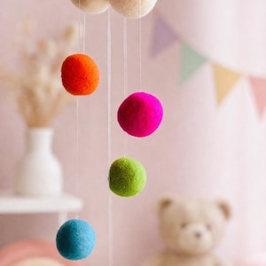 Mobile nuage en feutre fait main aux couleurs douces, idéal pour une chambre d'enfant, une nurserie ou comme cadeau de naissance.
