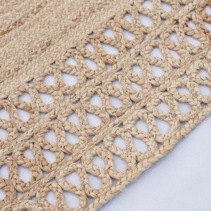 May include: A natural fibre rug with a woven design featuring a pattern of small, open circles. The rug is made of a light brown material and has a natural, rustic look.