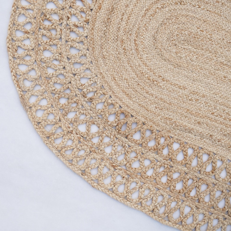 May include: An oval rug made from natural fibres with a woven border. The border has a delicate, openwork design.