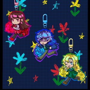 May include: Three double-sided 6.35 cm acrylic charms labelled Ib Charms. The charms feature anime-style characters with red, blue, and yellow roses against a dark blue grid background with colourful hand-drawn style stars and flower icons.