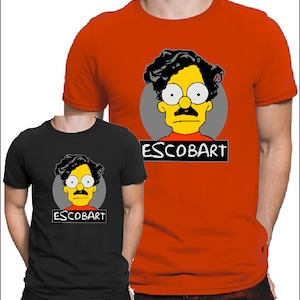 May include: Two t-shirts with a cartoon image of a yellow character with black hair, a mustache, and glasses. The character is wearing a red shirt. The text "ESCOBART" is printed on both shirts.