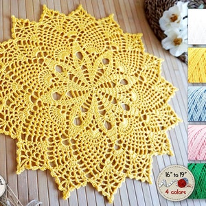 Crochet doily custom color and size in the shape of a 16-pointed star, with a very openwork texture forming a circle of original figures around the center, in the shape of eggs or pine cones.