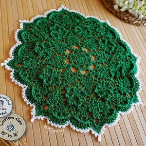 Hand crochet doily in bright emerald green edged with white little waves. Thin thickness yarn creating creative embossed shamrocks in a circle around the center of the piece.