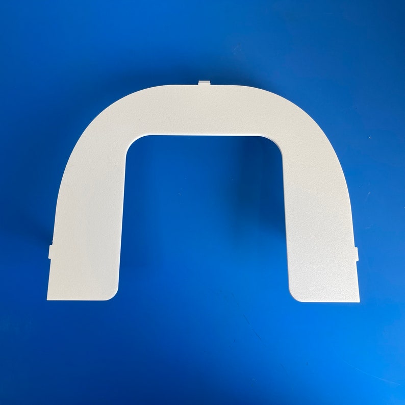 May include: White plastic archway shaped like a doorway. The archway is a simple design with a rounded top and straight sides.