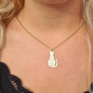 Halskette mit Anhänger aus Silber oder Gold. Kleine sitzende Katze mit gravierten Blumen aus Edelstahl