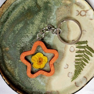 Wooden keychain in the shape of a star in resin and dried flower of buttercup Handmade Gift idea