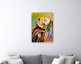 May include: An abstract painting of a woman with her head tilted back, eyes closed, and long hair. The artwork features vibrant colours, including yellow, green, red, and purple. The painting is displayed on a white wall above a grey sofa.