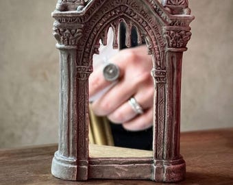 Rincón de lectura con espejo gótico: estilo catedral arqueada en miniatura, decoración fantástica, espejo en miniatura acotar